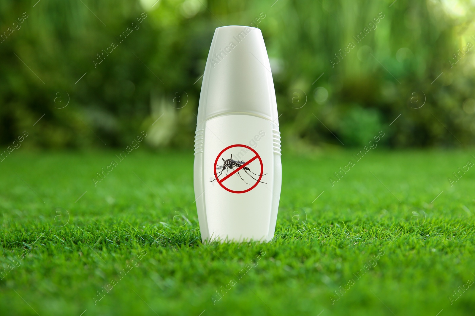 Image of Mosquito spray on green grass outdoors. Insect repellent