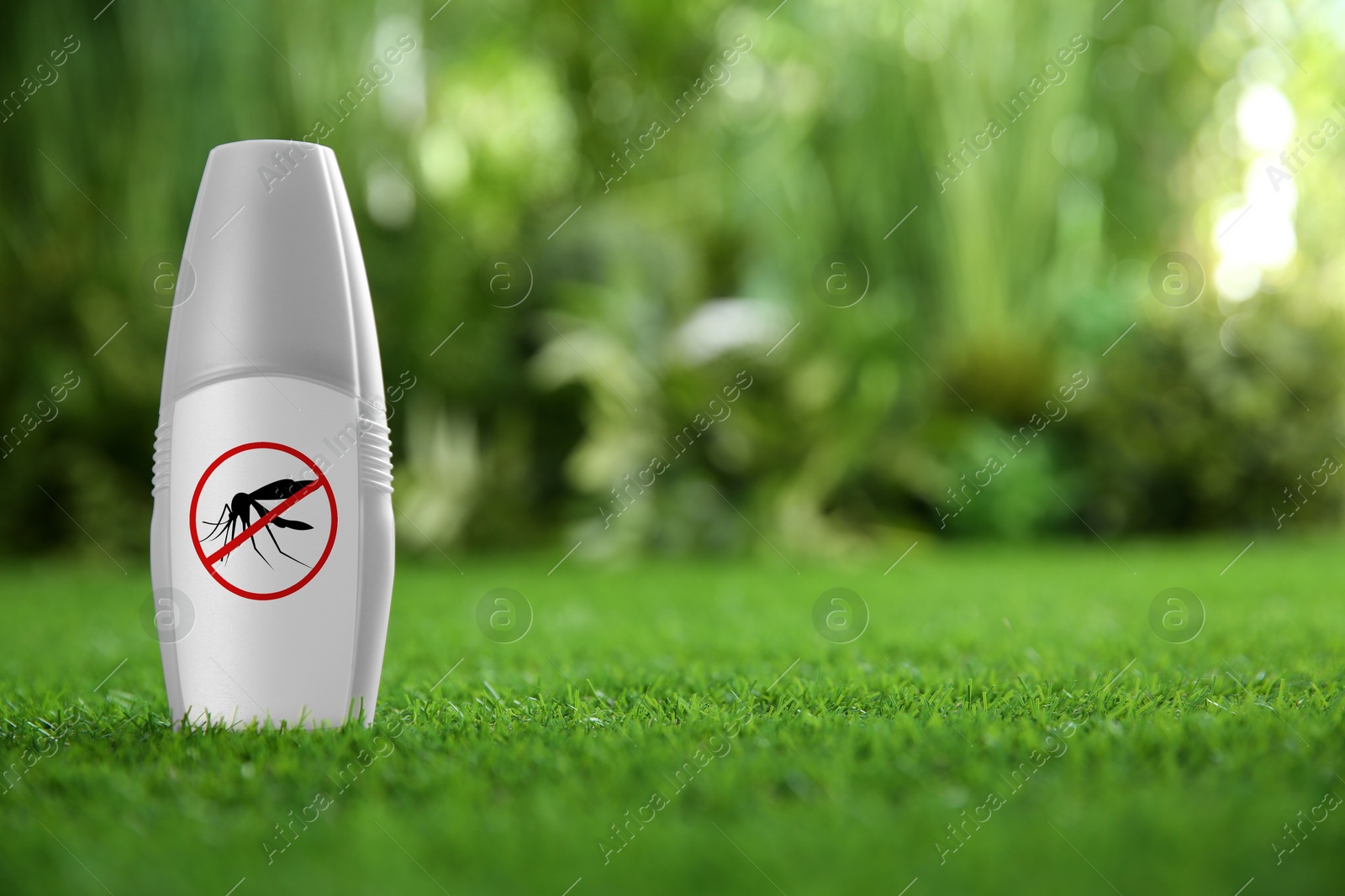 Image of Mosquito spray on green grass outdoors, space for text. Insect repellent