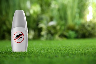 Image of Mosquito spray on green grass outdoors, space for text. Insect repellent