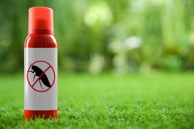 Insect repellent in spray can on green grass outdoors. Space for text