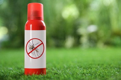 Mosquito spray on green grass outdoors, space for text. Insect repellent