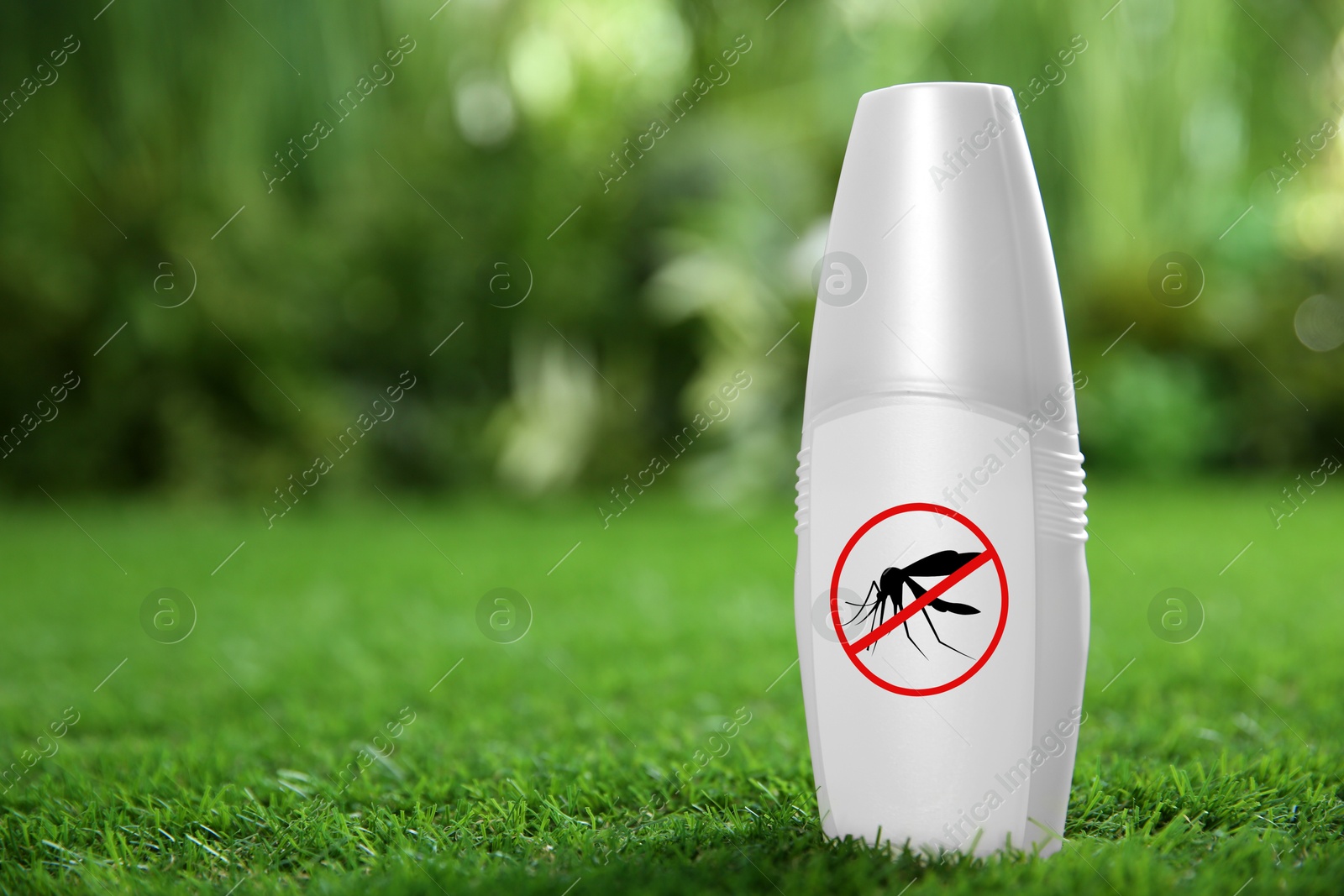 Image of Mosquito spray on green grass outdoors, space for text. Insect repellent