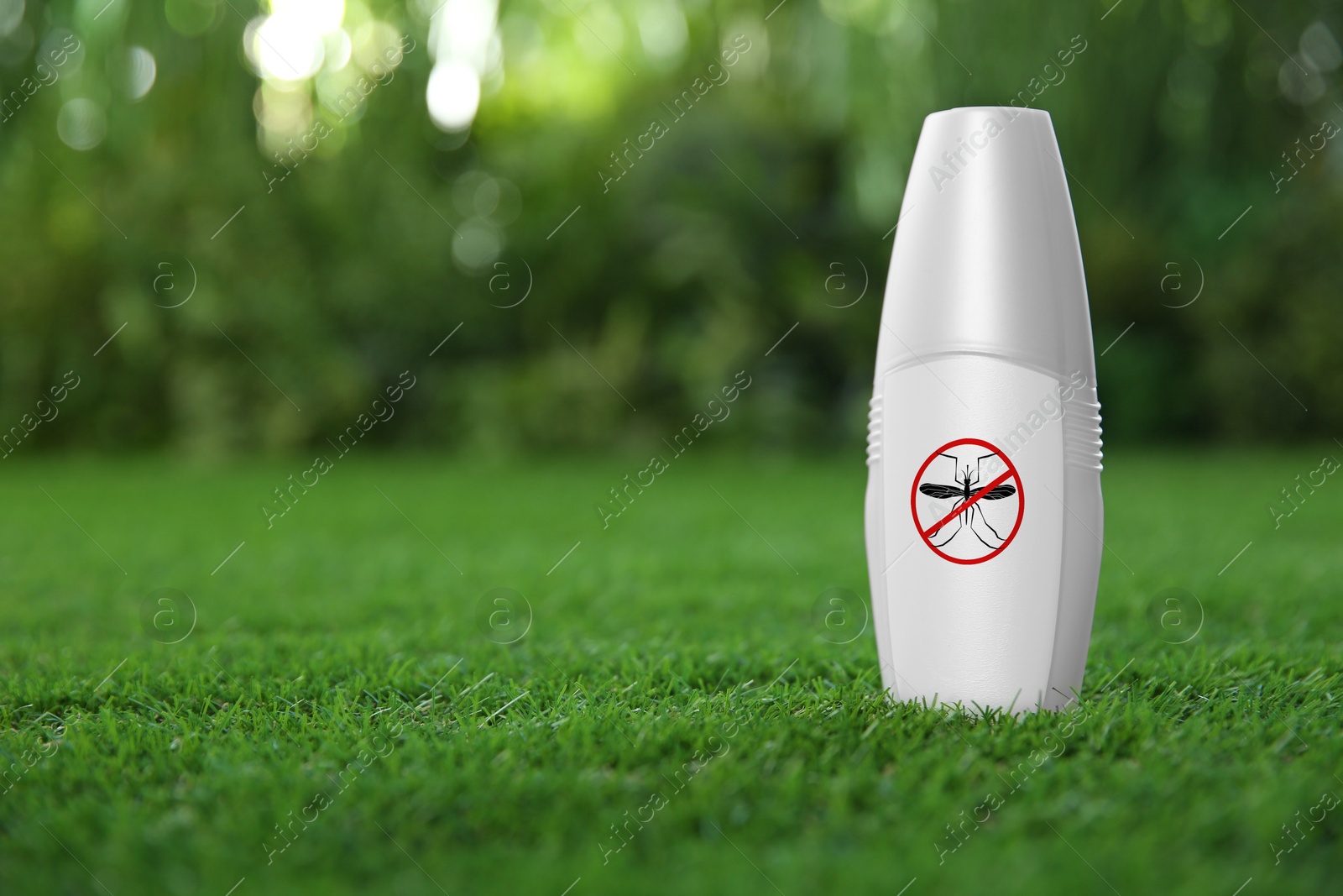 Image of Mosquito spray on green grass outdoors, space for text. Insect repellent