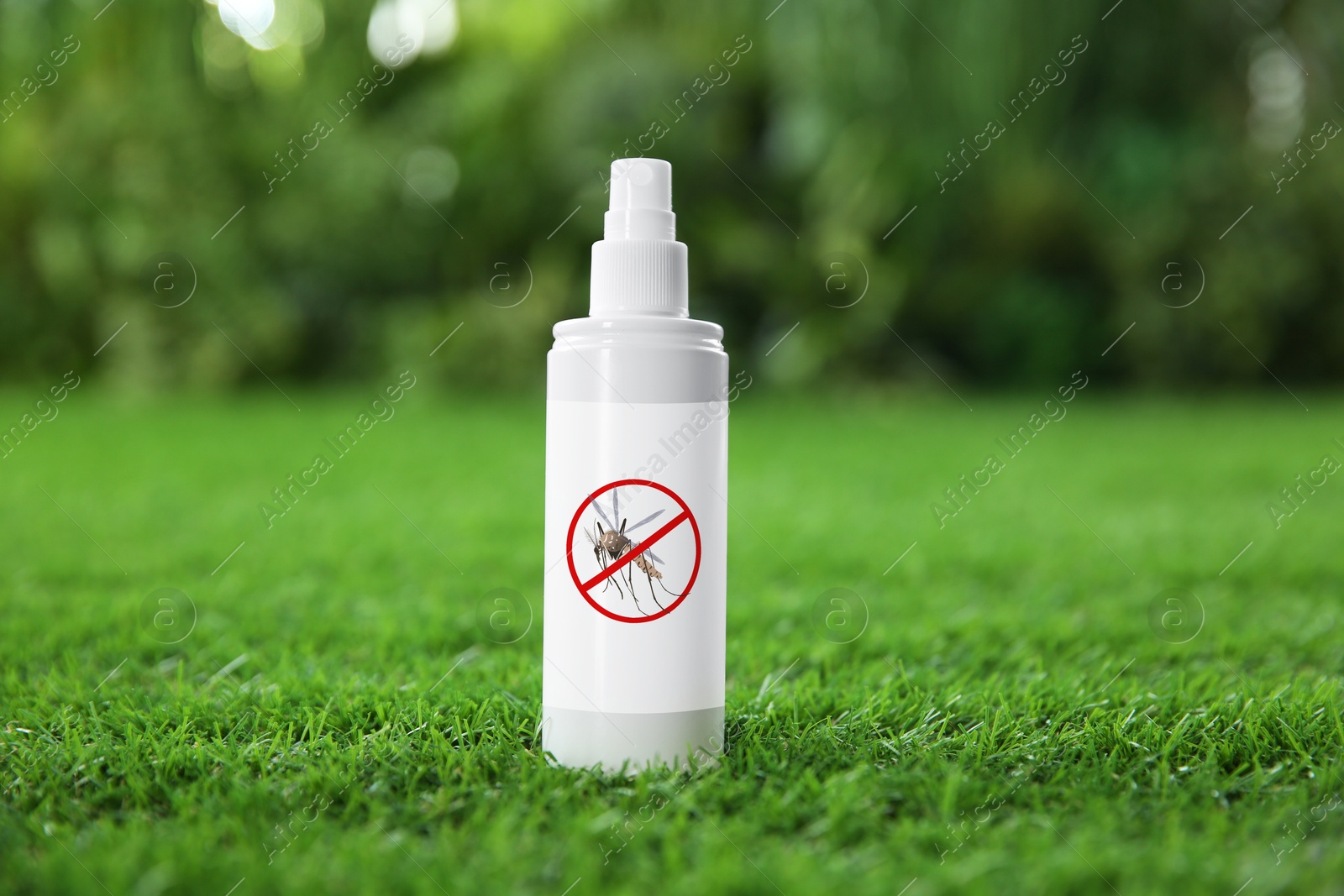 Image of Mosquito spray on green grass outdoors. Insect repellent