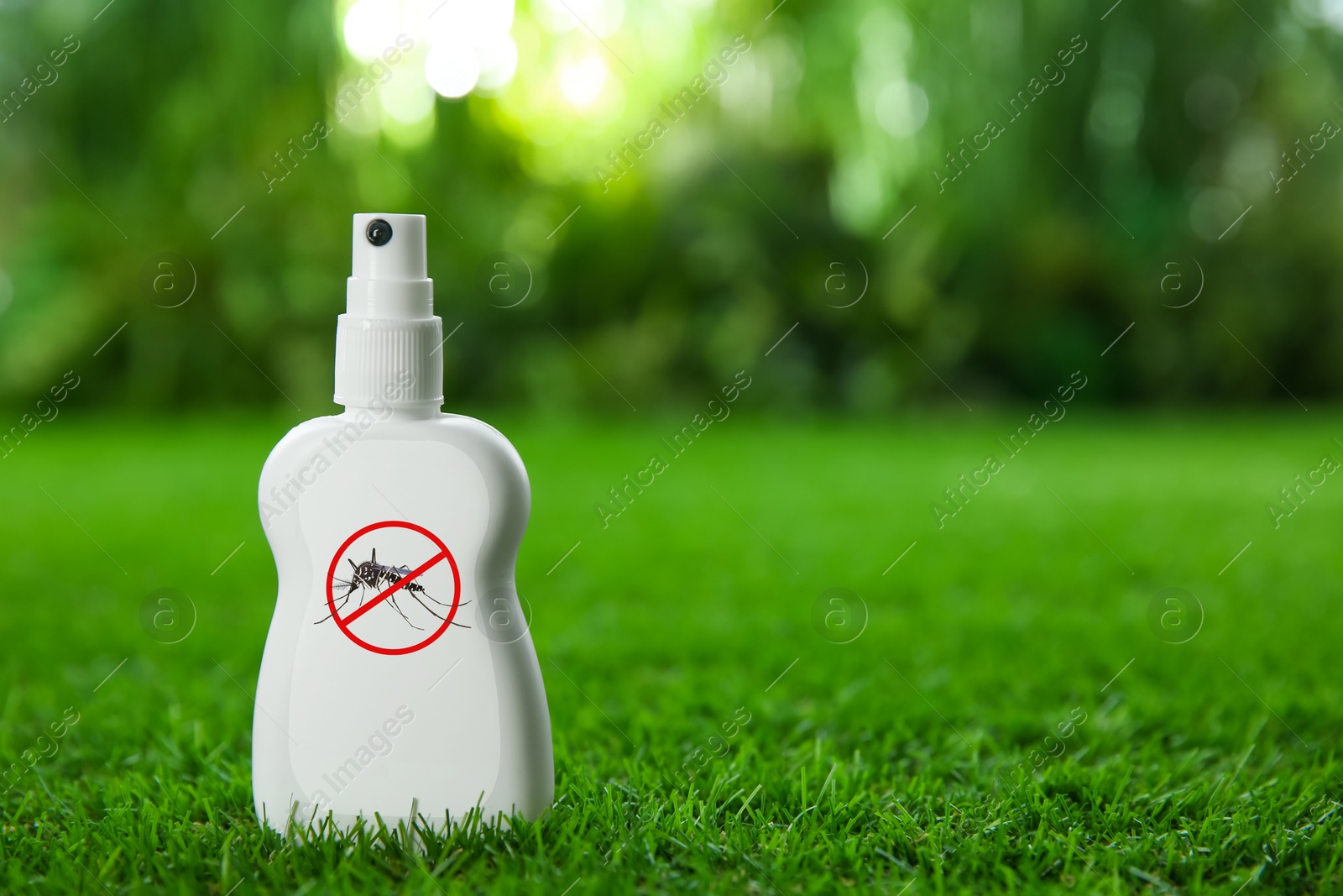 Image of Mosquito spray on green grass outdoors, space for text. Insect repellent