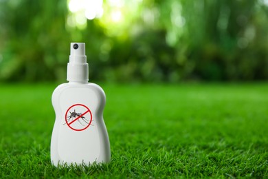 Image of Mosquito spray on green grass outdoors, space for text. Insect repellent