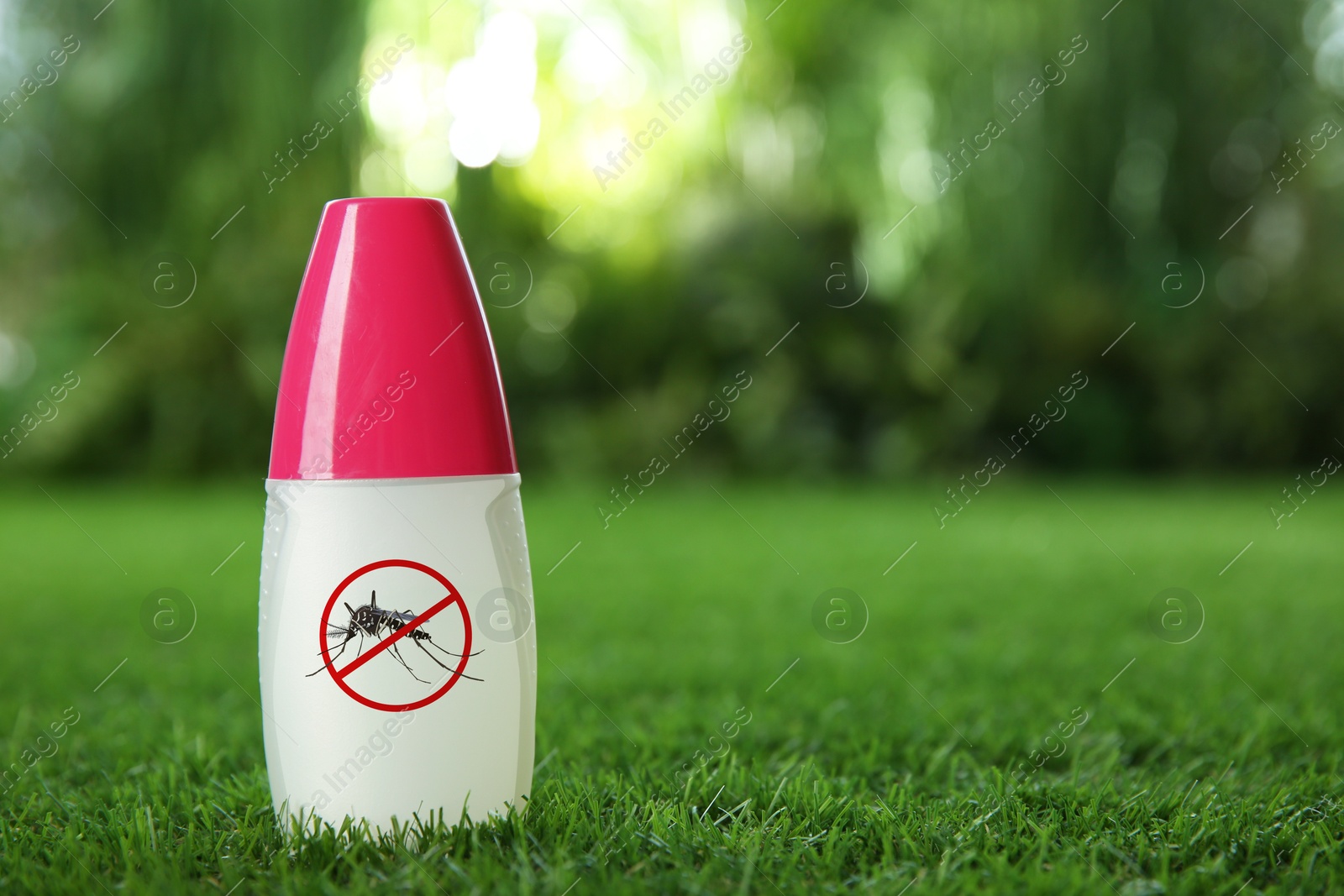 Image of Mosquito spray on green grass outdoors, space for text. Insect repellent