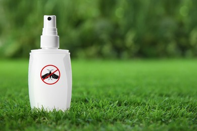 Image of Insect repellent in spray bottle on green grass outdoors. Space for text