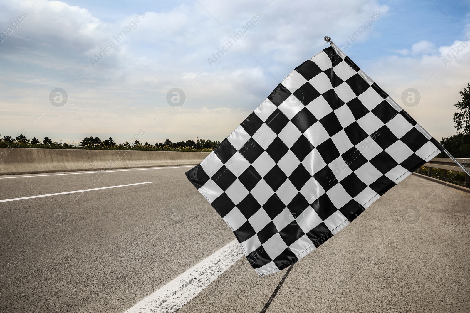 Image of Checkered finish flag and asphalt racing track outdoors