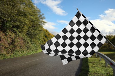 Checkered finish flag and asphalt racing track outdoors