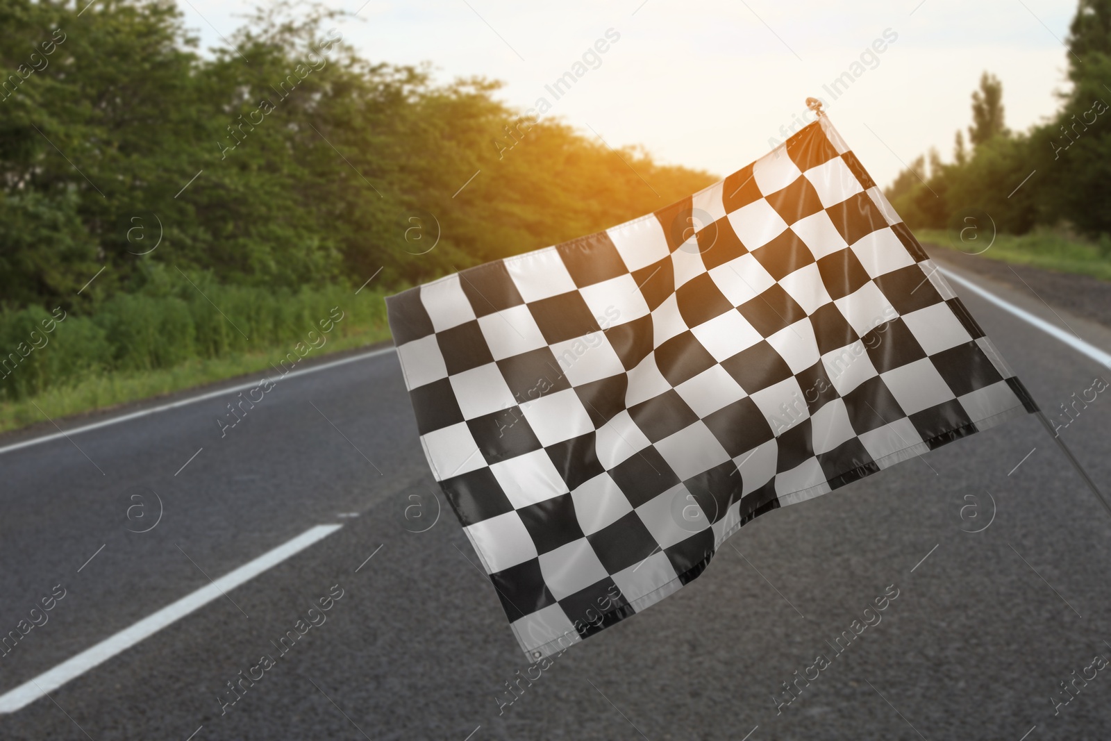 Image of Checkered finish flag and asphalt racing track outdoors