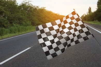 Checkered finish flag and asphalt racing track outdoors