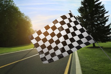 Checkered finish flag and asphalt racing track outdoors