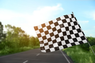 Checkered finish flag and asphalt racing track outdoors