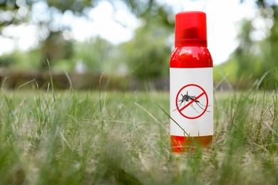 Image of Mosquito spray on green grass outdoors, space for text. Insect repellent