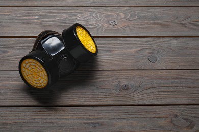 Photo of One respirator mask on wooden table, top view. Space for text