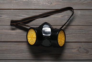 One respirator mask on wooden table, top view