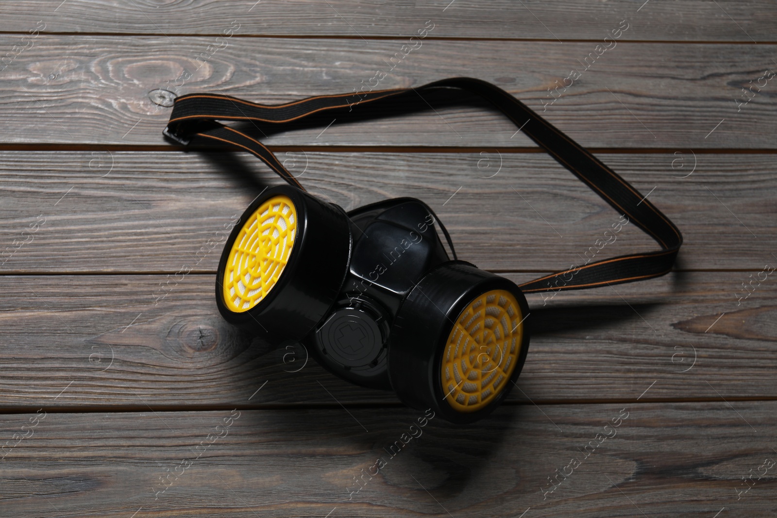 Photo of One respirator mask on wooden table, top view