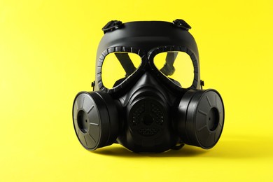 Photo of One gas mask on yellow background. Safety equipment