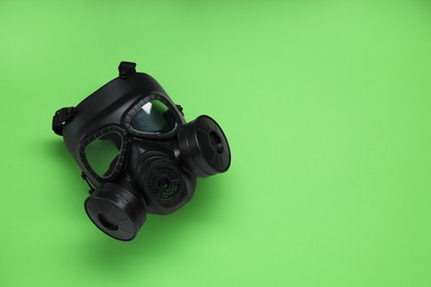 One gas mask on green background, top view. Space for text