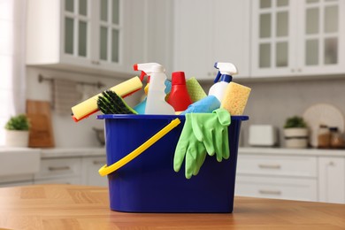 Cleaning service. Bucket with supplies on table in kitchen