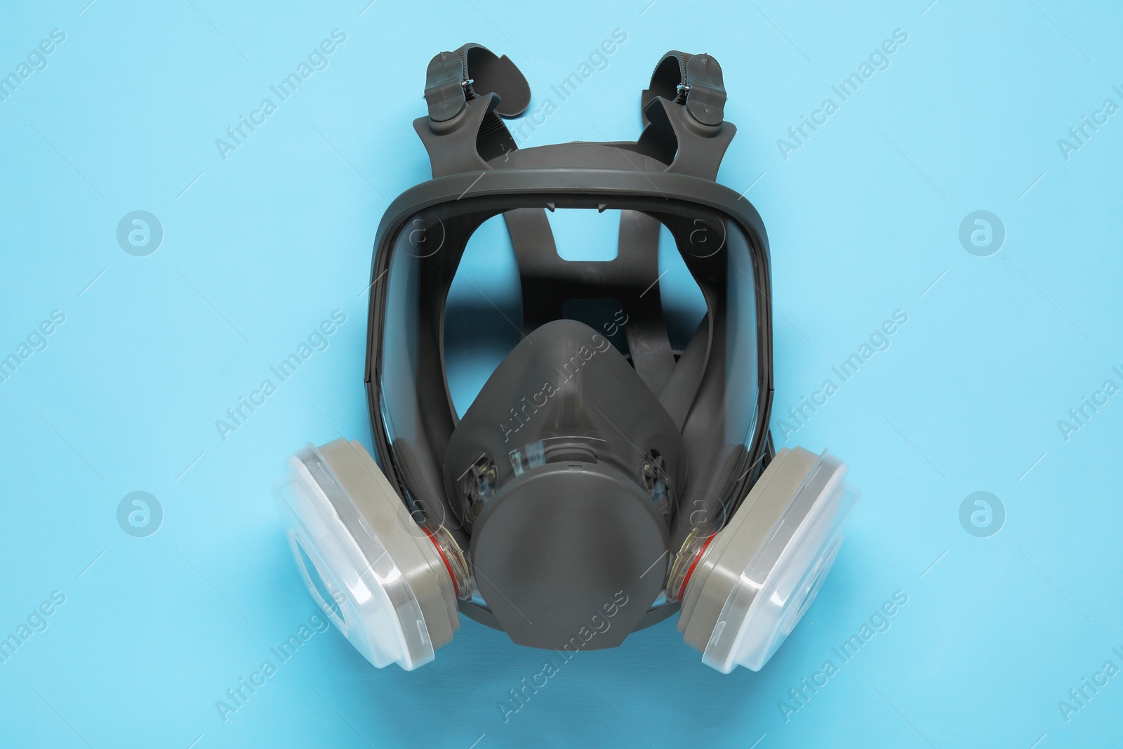 Photo of One full face respirator on light blue background, top view