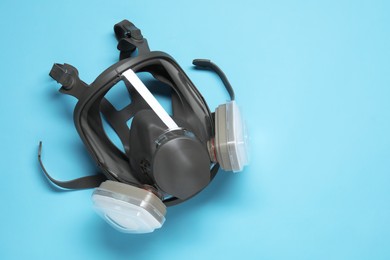 Photo of One full face respirator on light blue background, top view. Space for text