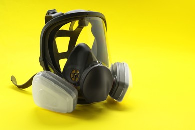 One full face respirator on yellow background, closeup. Space for text