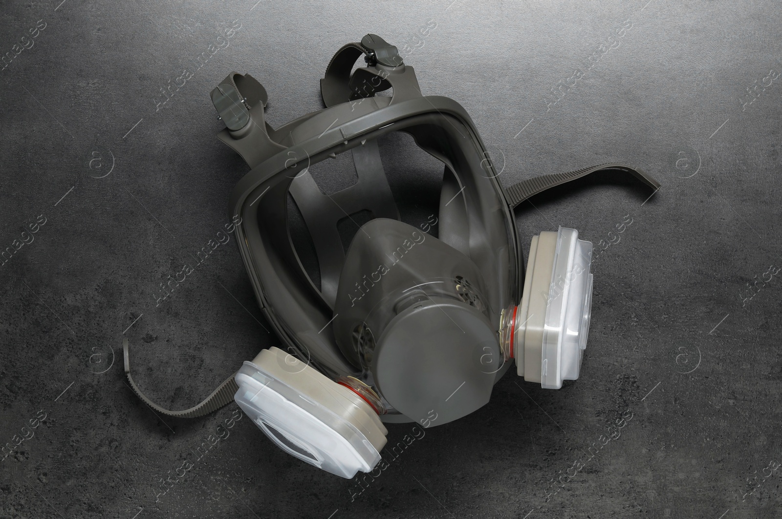 Photo of One full face respirator on dark textured table, top view