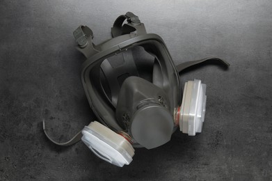 Photo of One full face respirator on dark textured table, top view