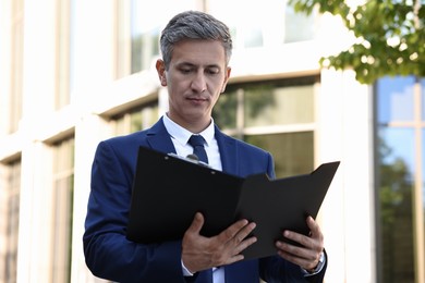 International relations. Diplomat with clipboard in suit outdoors