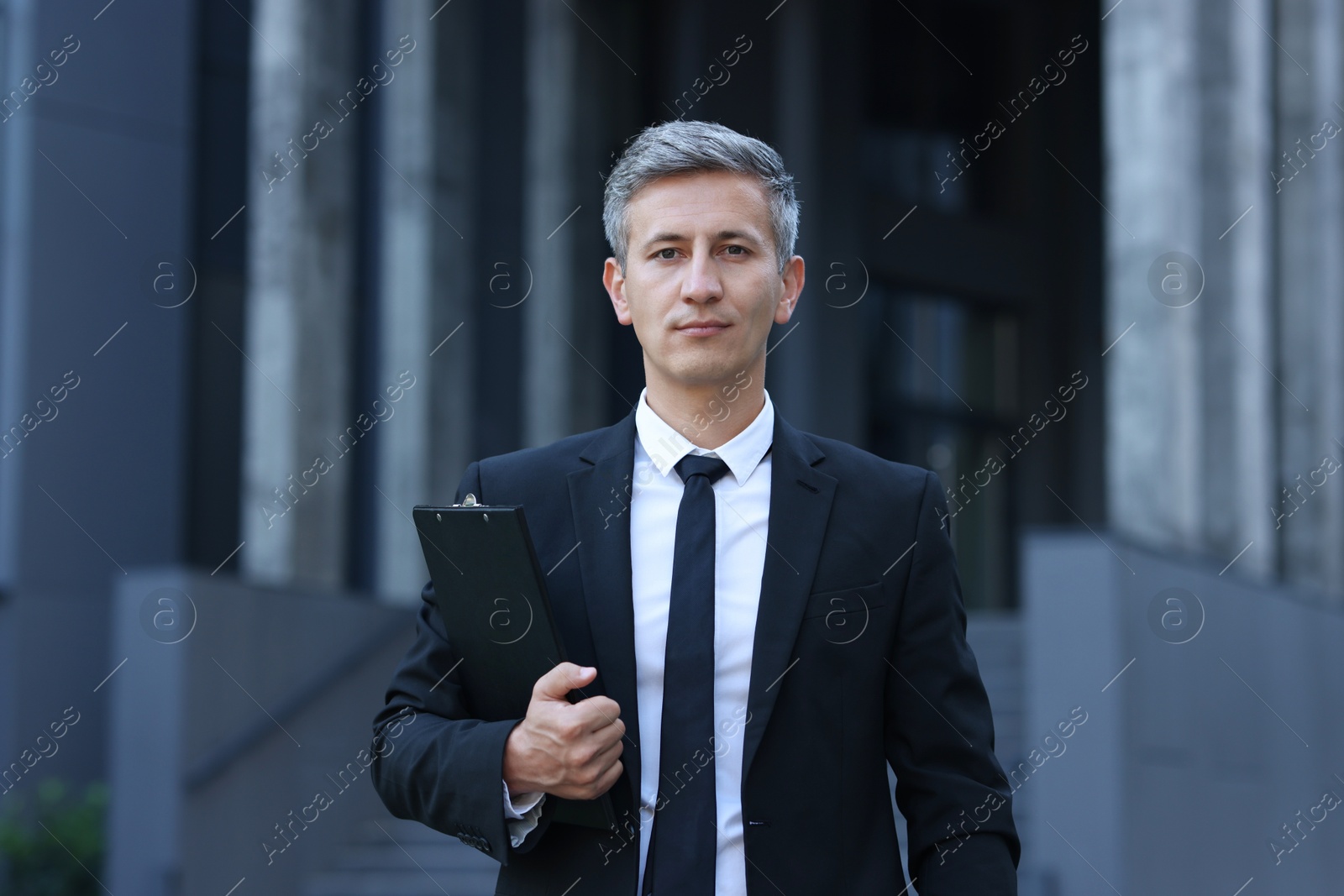 Photo of International relations. Diplomat with clipboard in suit outdoors