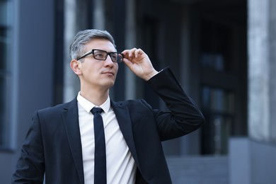 International relations. Diplomat with glasses in suit outdoors, space for text