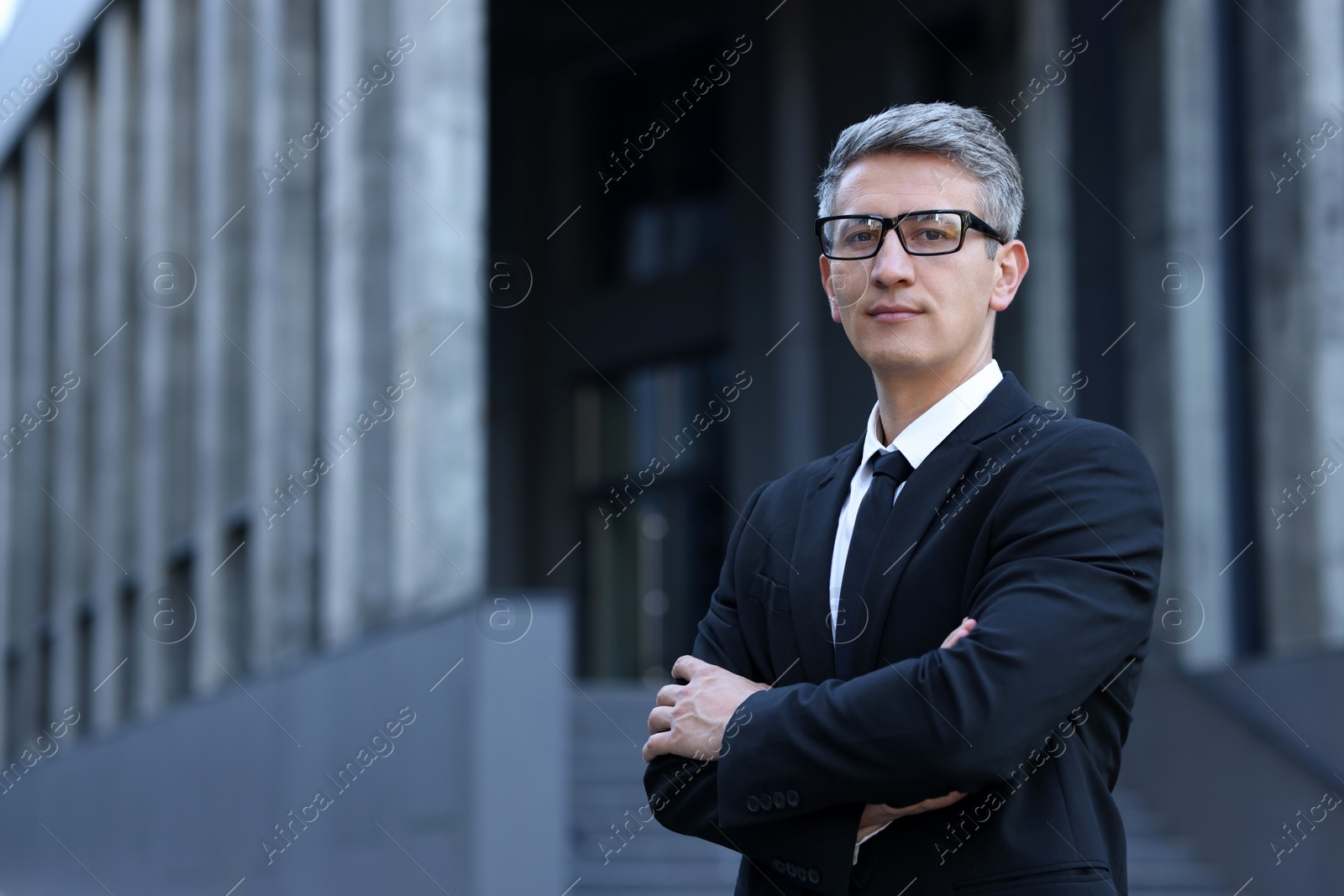 Photo of International relations. Diplomat with crossed arms in suit outdoors, space for text