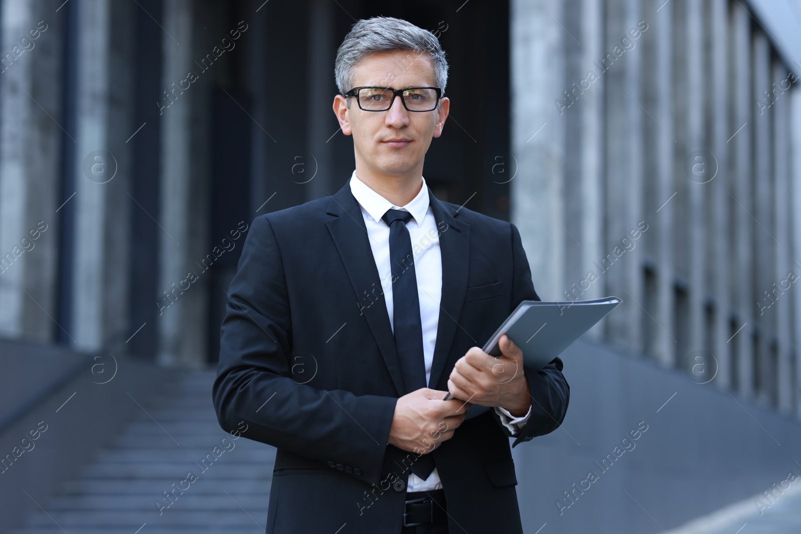 Photo of International relations. Diplomat with clipboard in suit outdoors