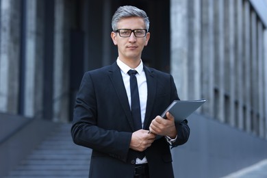 Photo of International relations. Diplomat with clipboard in suit outdoors