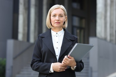 Photo of International relations. Diplomat with clipboard in suit outdoors