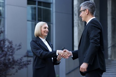 Photo of International relations. Diplomats shaking hands during meeting outdoors