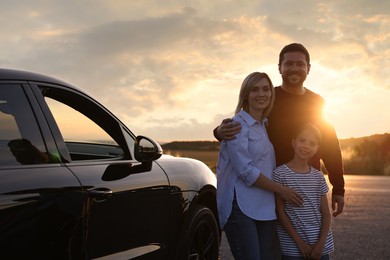 Cute family near car outdoors at sunset