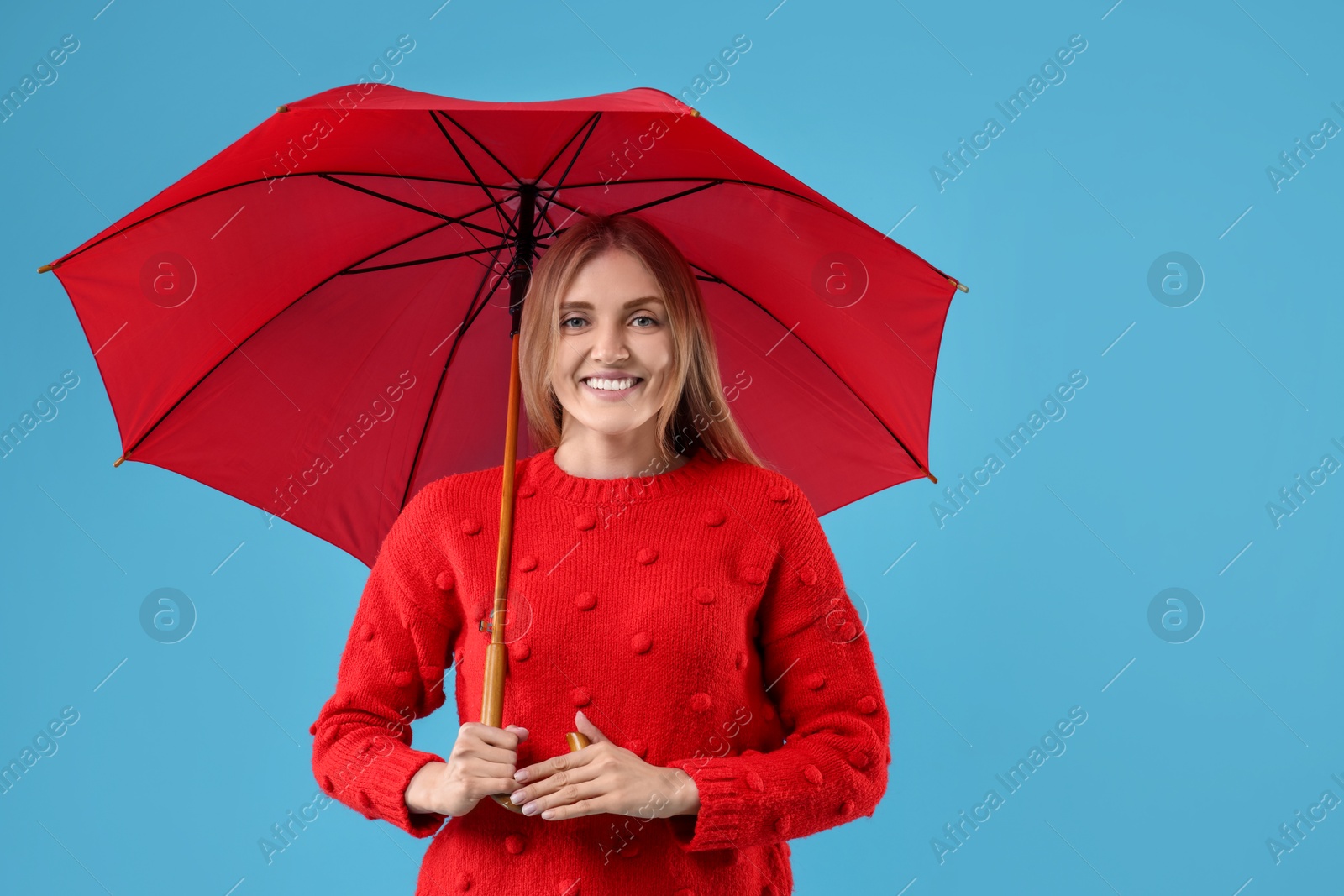 Photo of Woman with red umbrella on light blue background