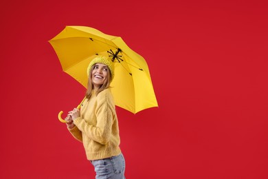 Photo of Woman with yellow umbrella on red background