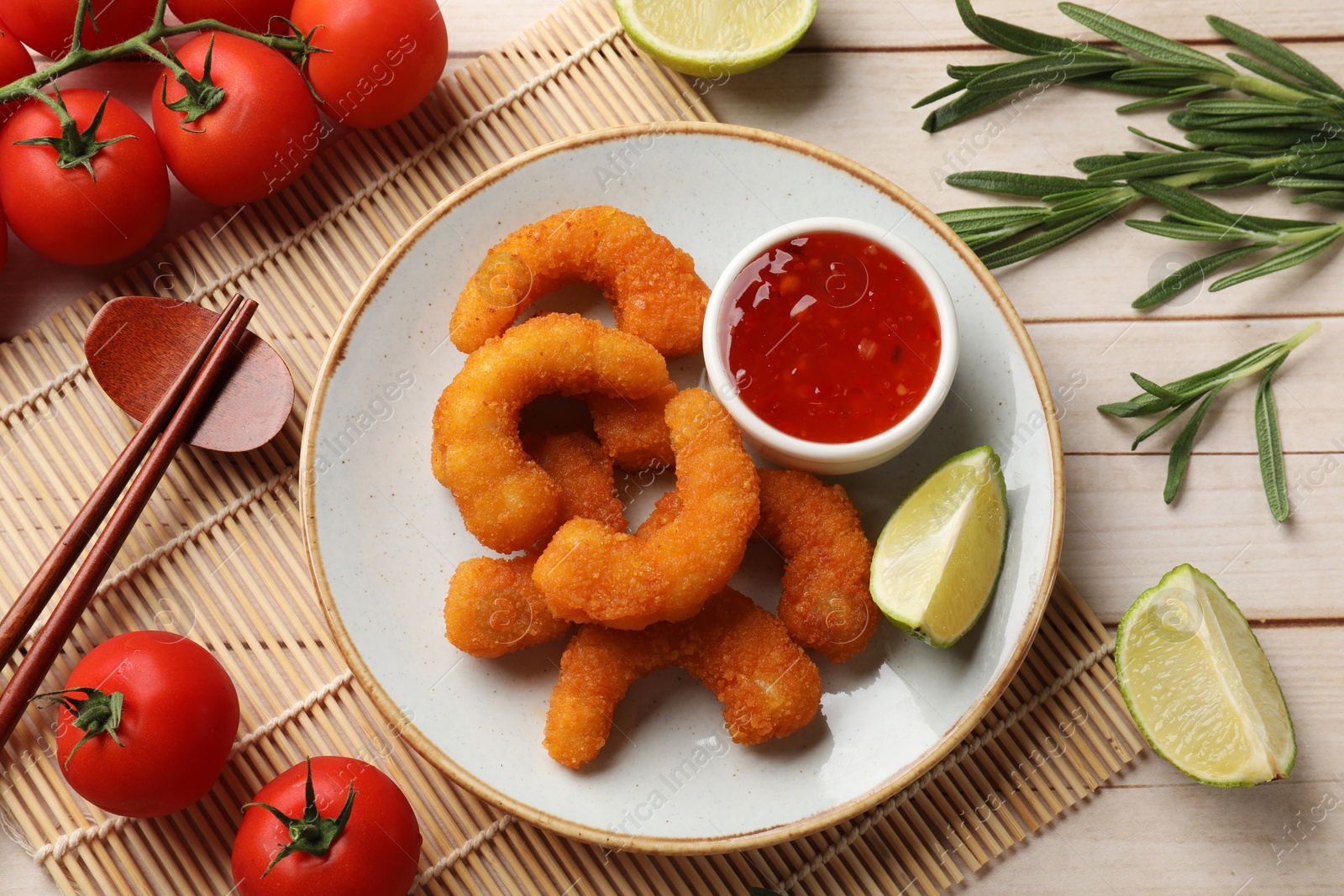 Photo of Tasty breaded fried shrimps served on light wooden table, flat lay