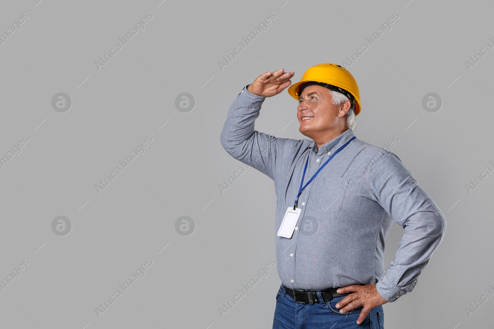 Photo of Engineer in hard hat on grey background, space for text