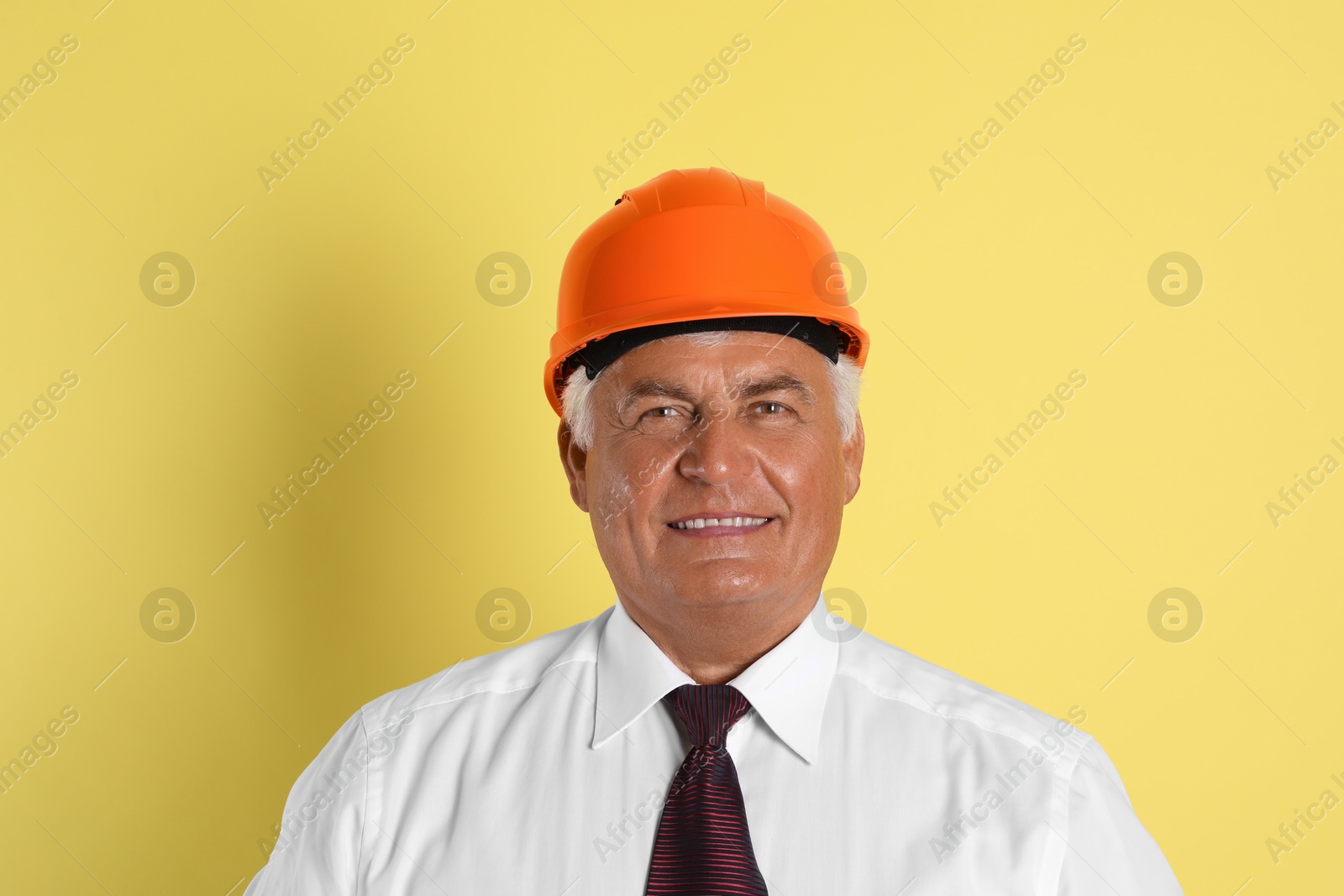 Photo of Engineer in hard hat on yellow background