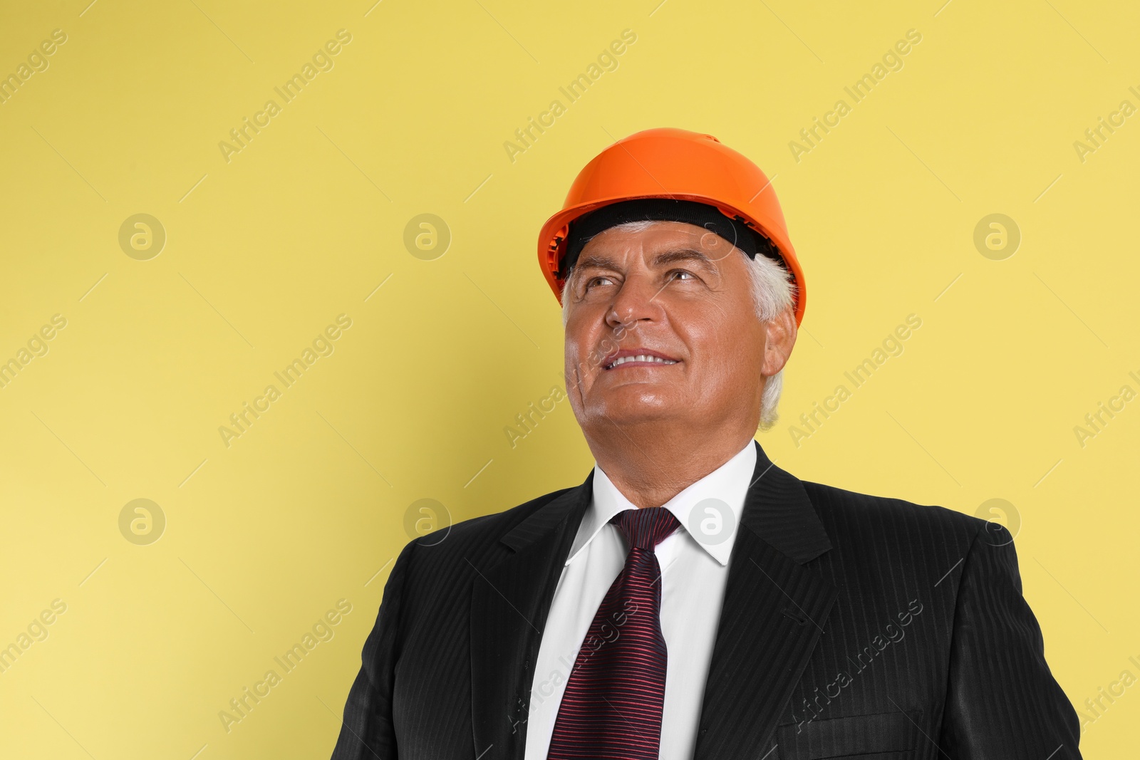 Photo of Engineer in hard hat on yellow background