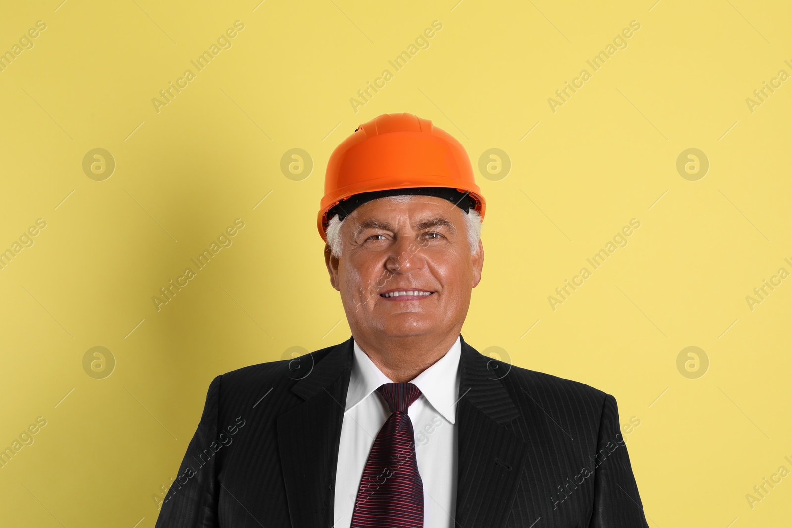 Photo of Engineer in hard hat on yellow background