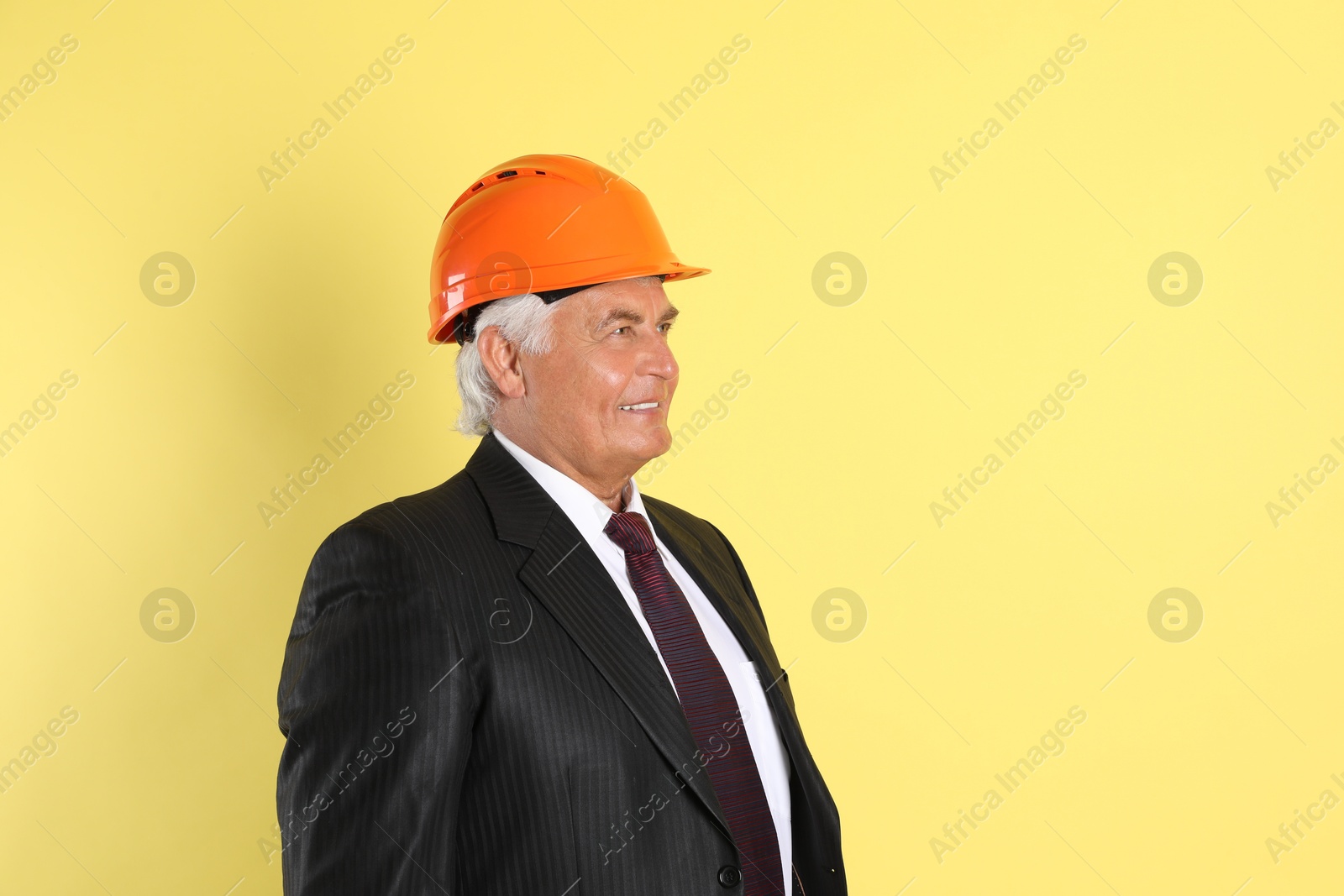 Photo of Engineer in hard hat on yellow background, space for text