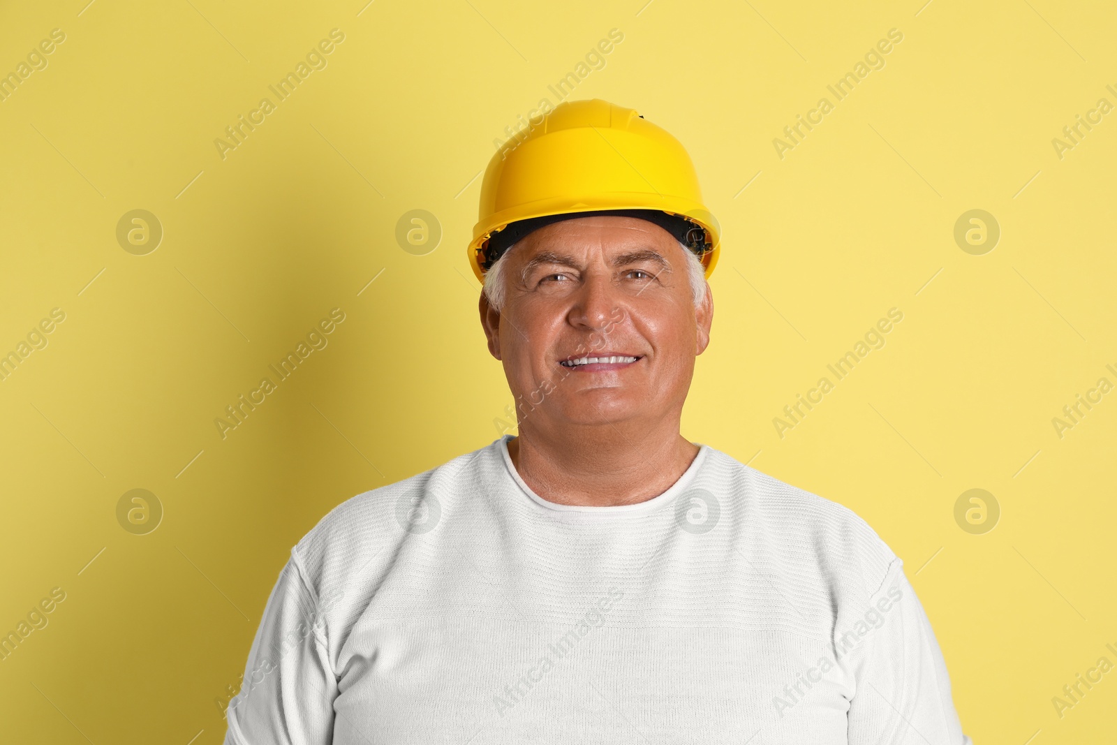 Photo of Engineer in hard hat on yellow background