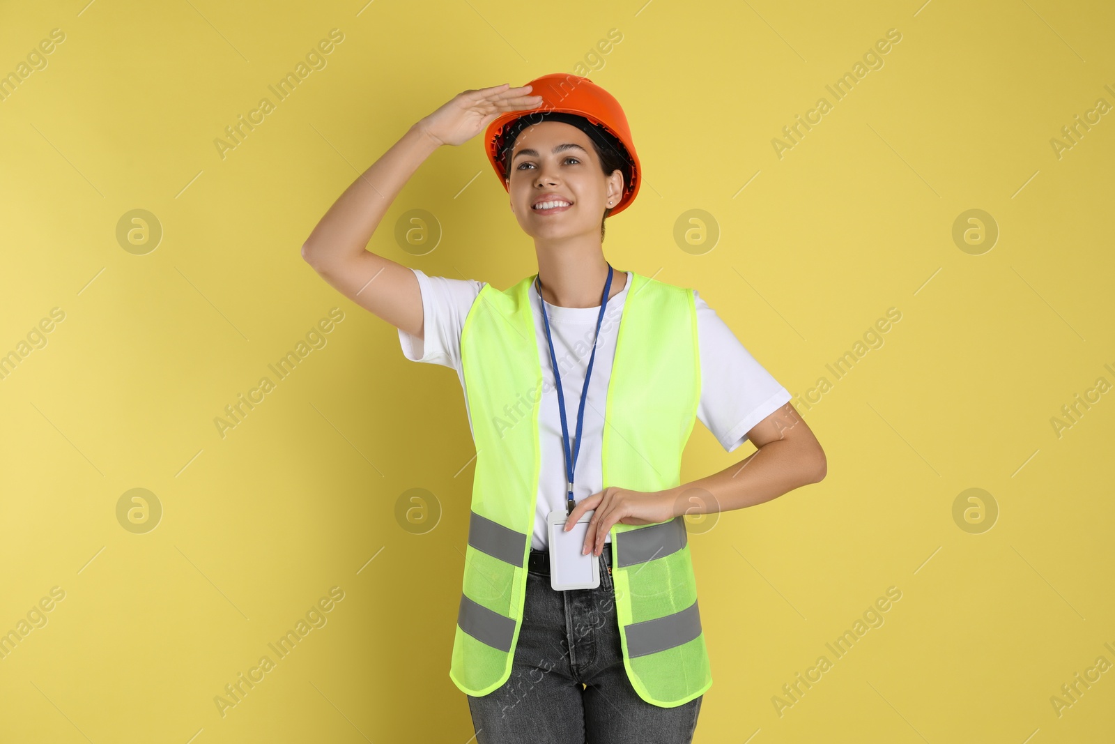 Photo of Engineer in hard hat on yellow background