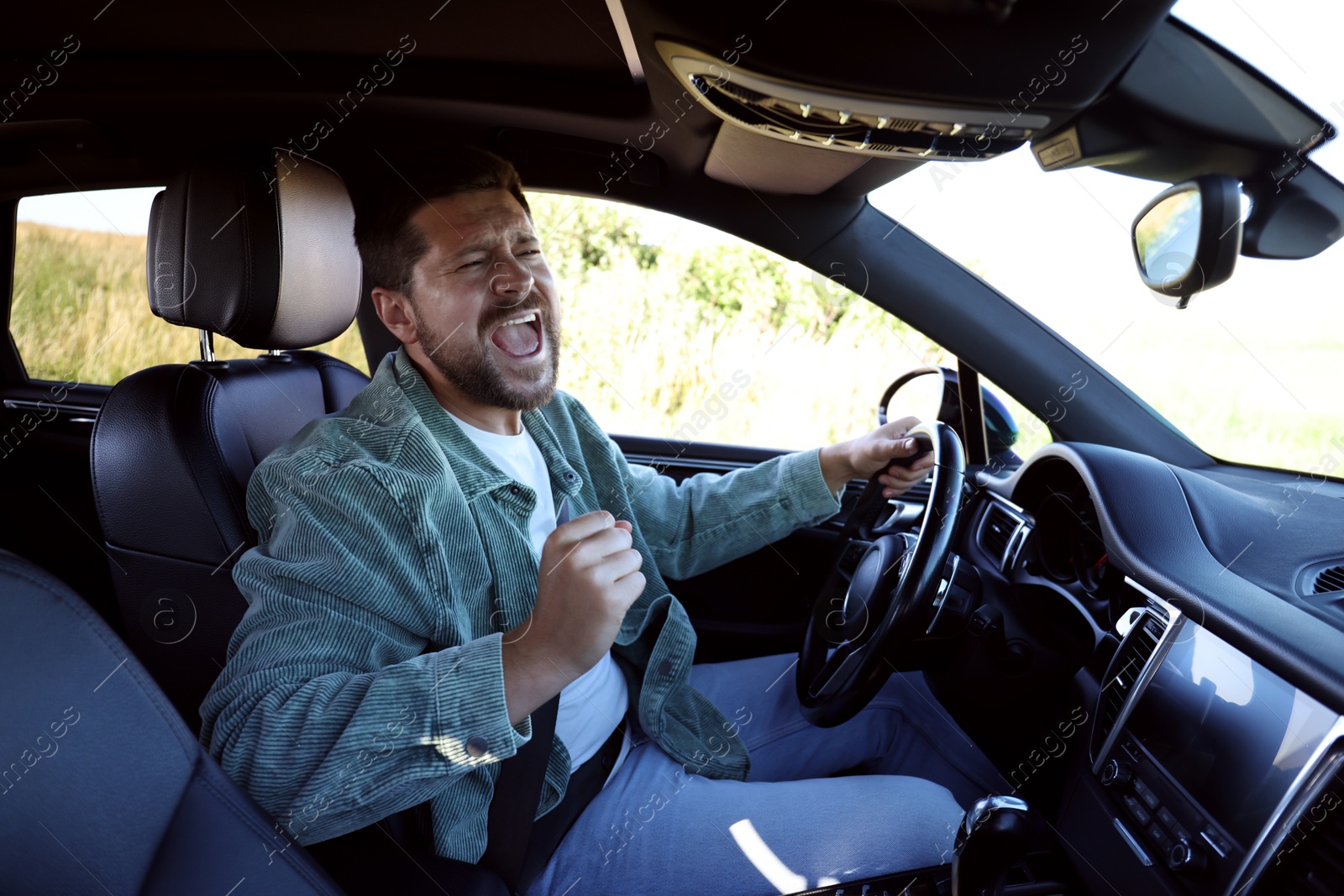 Photo of Man singing in car, view from inside